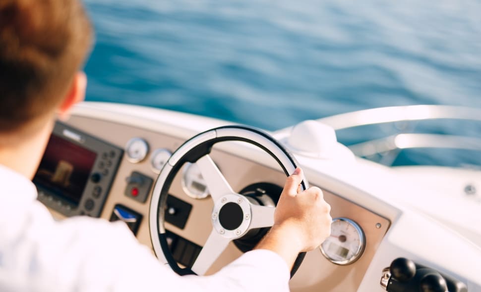 Un pilote à la barre d’un bateau de plaisance en mer