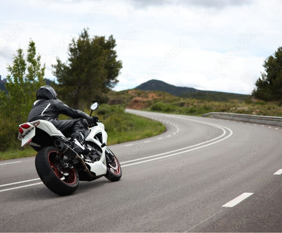 Un motard en virage sur une route de montagne