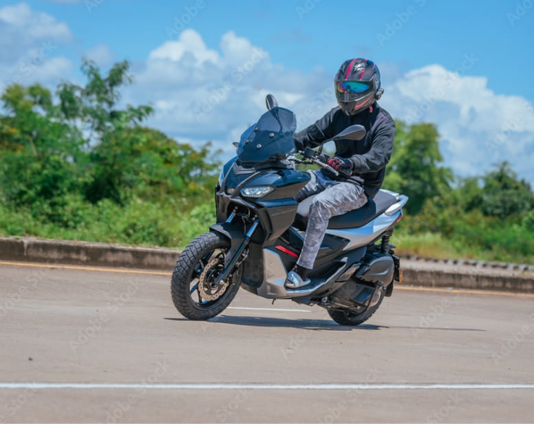 Un scooter trois-roues en virage sur une piste d’exercice