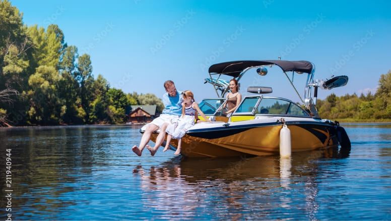 Une famille assise à l’arrière d’un bateau de plaisance sur une rivière